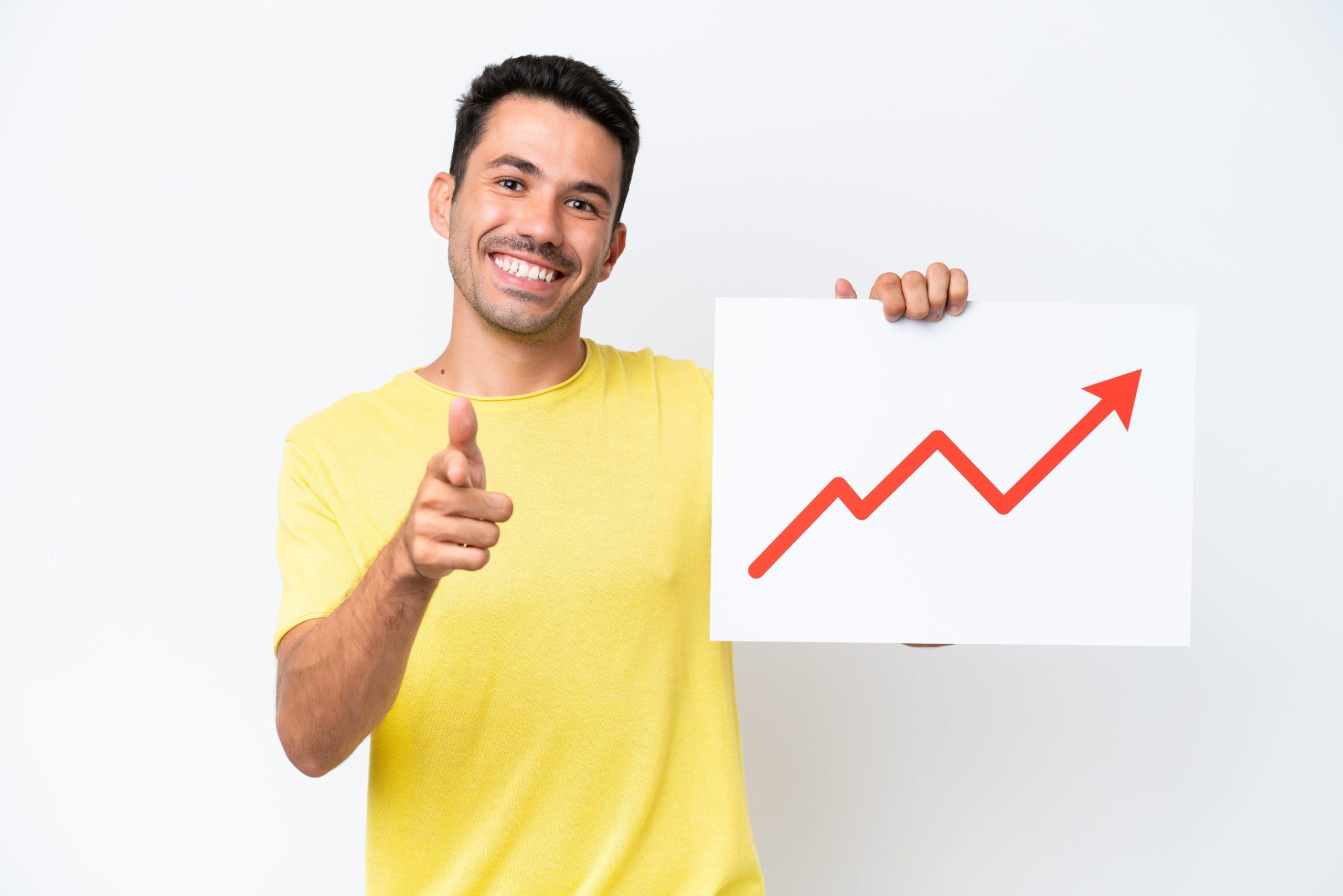 Young handsome man over isolated white background holding a sign with a growing statistics arrow symbol and pointing to the front